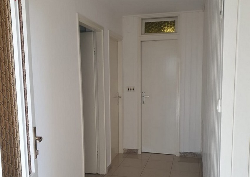 Corridoio con porte bianche e sopraluce sopra la porta dell'appartamento