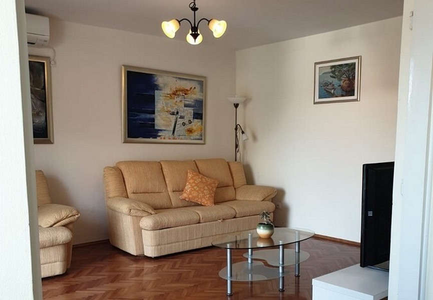 Soggiorno con divano beige e quadro alla parete