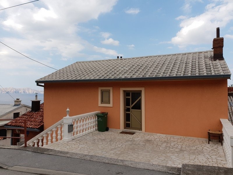 Casa arancione con terrazza in pietra e balaustra