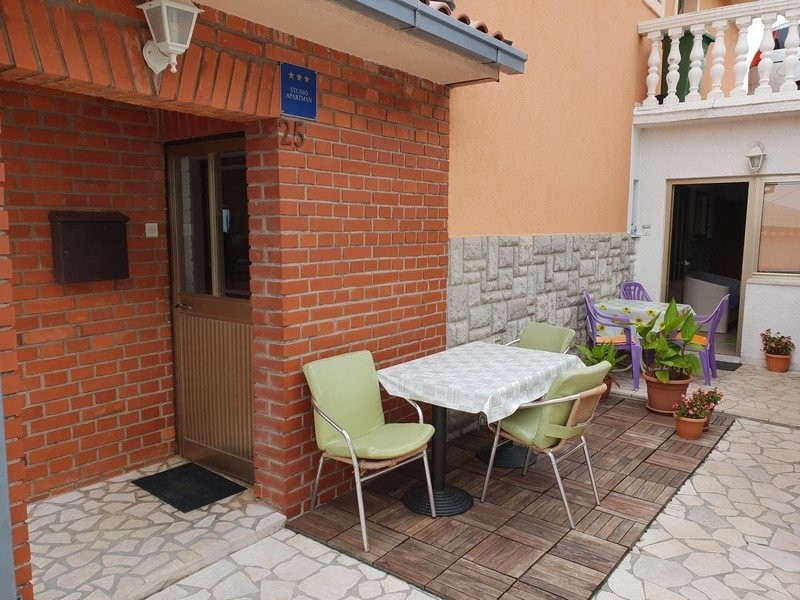 Zona seduta con tavolo e sedie davanti all'ingresso in mattoni