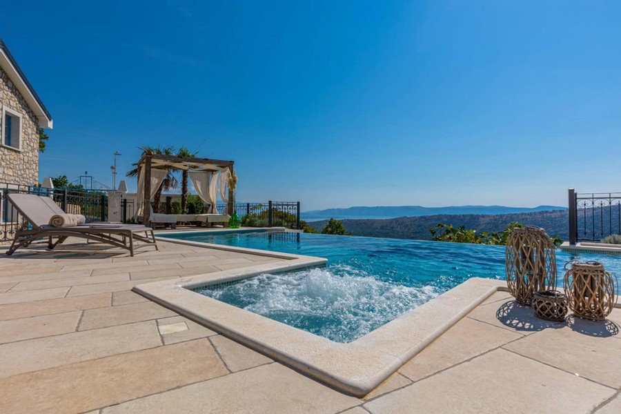 Idromassaggio accanto alla piscina a sfioro con padiglione e ampia vista