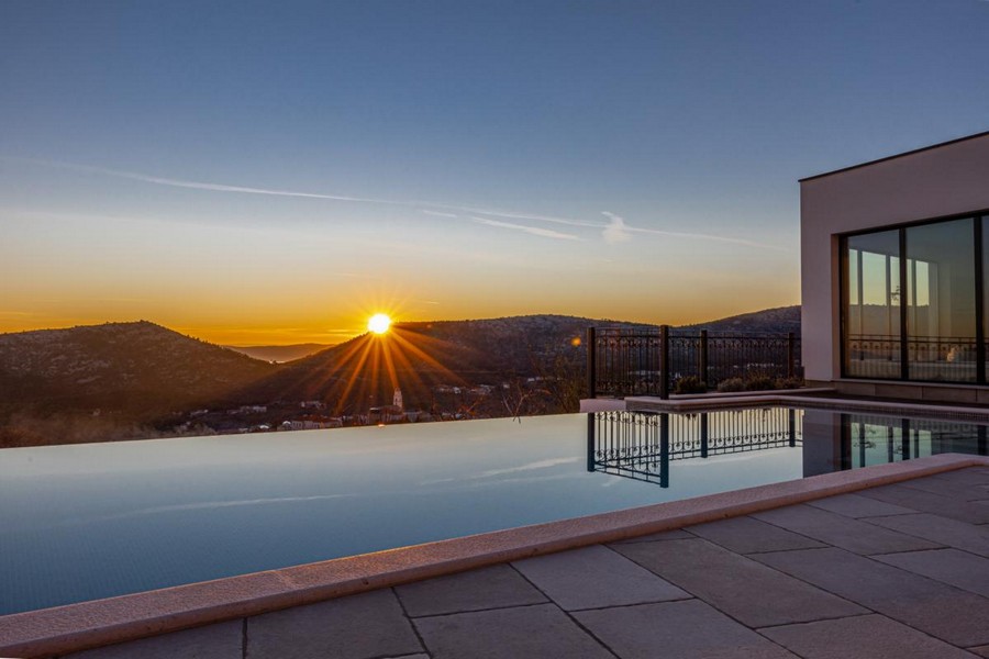 Piscina a sfioro al tramonto sopra le colline
