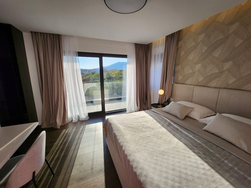 Camera da letto beige con letto matrimoniale e finestra sulla terrazza