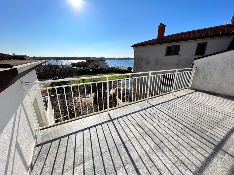Terrazza soleggiata con ringhiera bianca e vista sulla laguna