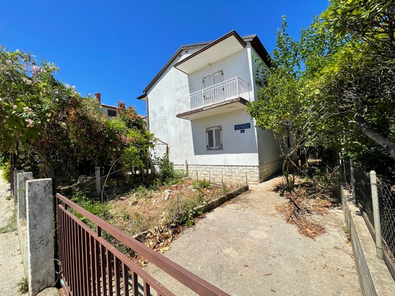Casa con balcone dietro il cancello metallico all'ingresso