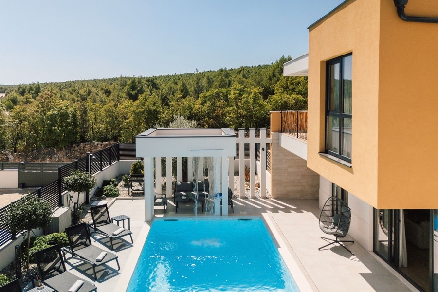 Piscina con zona salotto coperta e vista sul verde