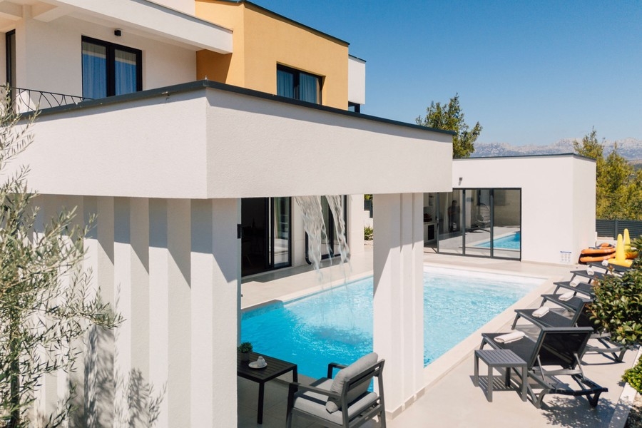 Terrazza della piscina con lettini e zona salotto coperta