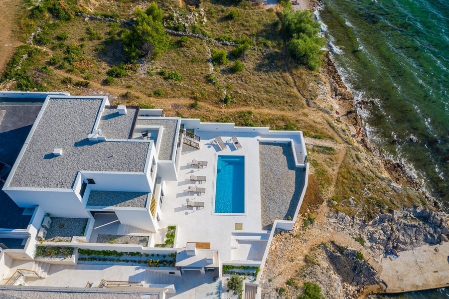 Vista aerea della villa con piscina direttamente sopra la costa rocciosa
