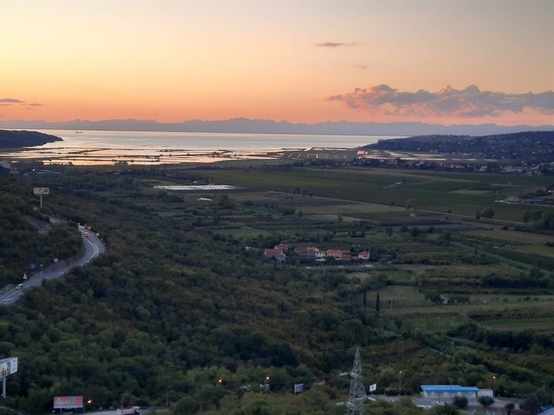Tramonto sulla baia con campi e strada nella valle