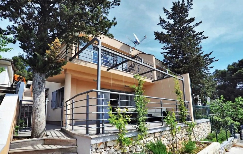 Casa con ringhiere in acciaio e pino davanti alla terrazza