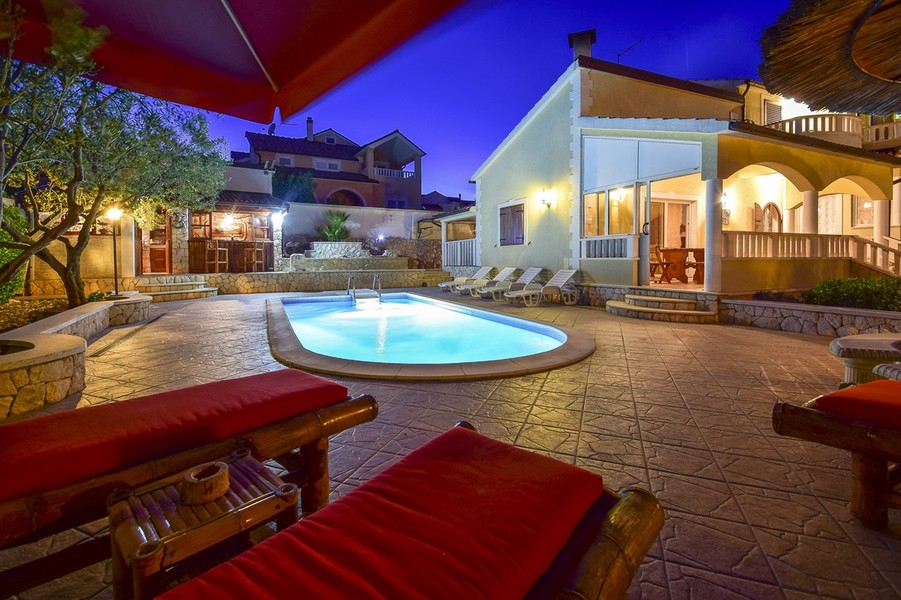 Villa H2618 in Croazia di notte con piscina illuminata.