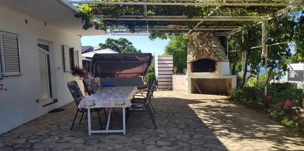 Terrazza con zona pranzo coperta e barbecue.