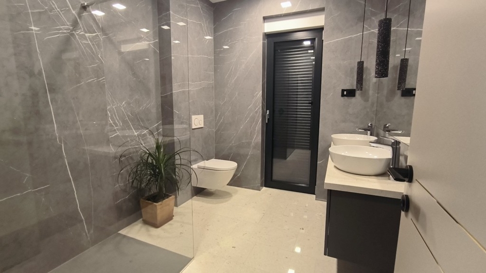 Ampio bagno con doccia a filo pavimento e doppio lavabo