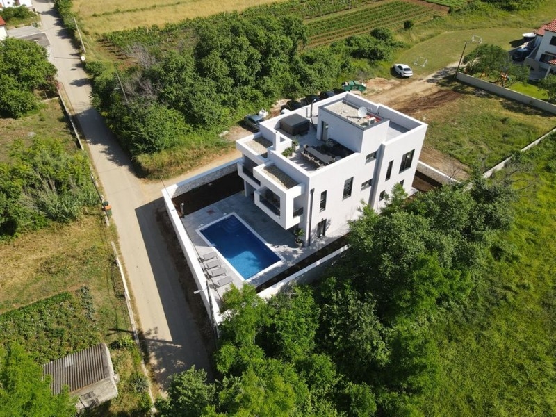 Veduta aerea di una villa di lusso con piscina in un ambiente verde