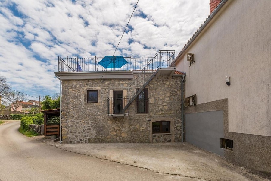 Casa in pietra con scala esterna verso la terrazza sul tetto nel vicolo