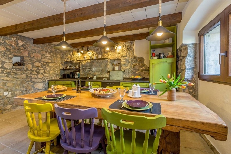 Zona pranzo mediterranea e vista sulla cucina in stile rustico di campagna. Panorama Scouting H2661, Croazia.