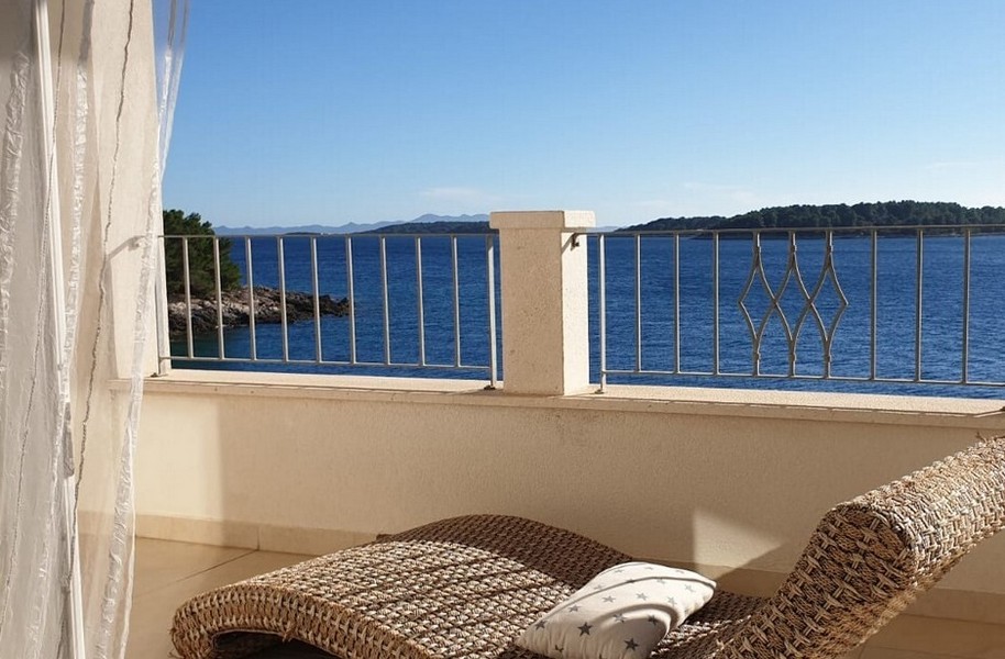 Terrazza con vista mare e una sdraio relax in vimini.