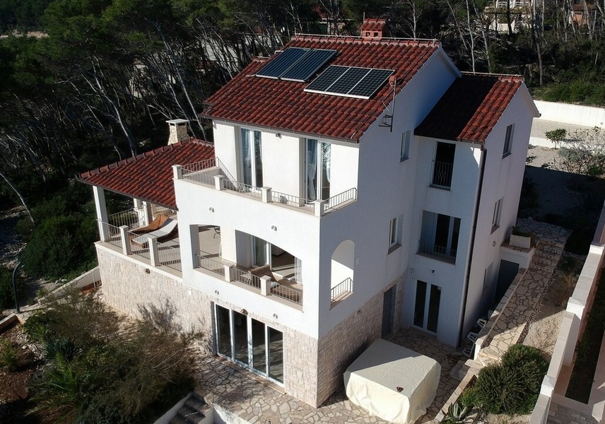 Casa bianca con pannelli solari e logge vista dall'alto