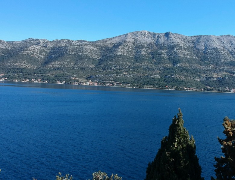 Cipressi davanti allo stretto con i monti dietro