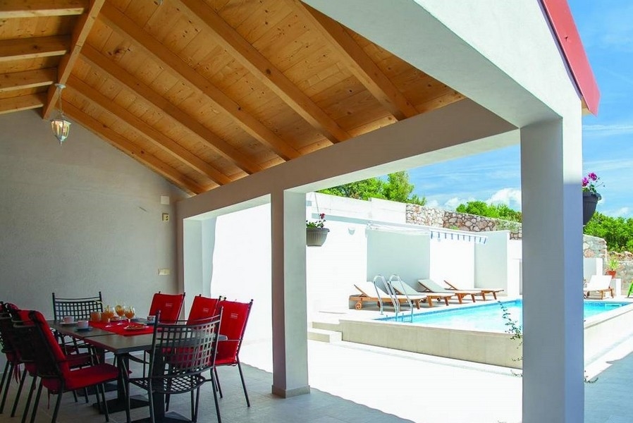 Zona pranzo coperta e vista sulla piscina.