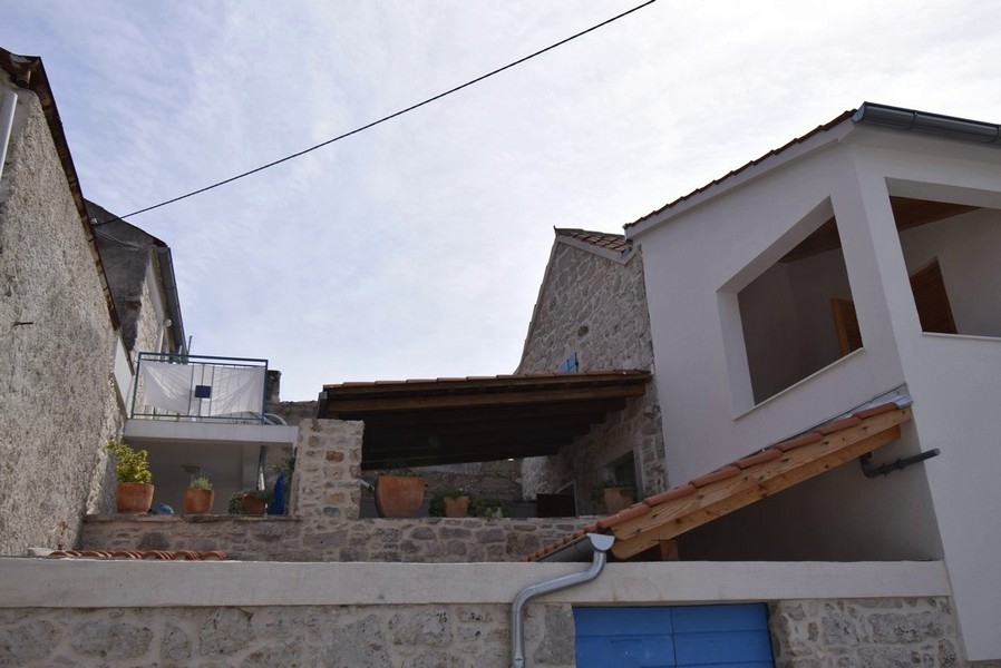 Case in pietra con vasi di fiori sul muro della terrazza