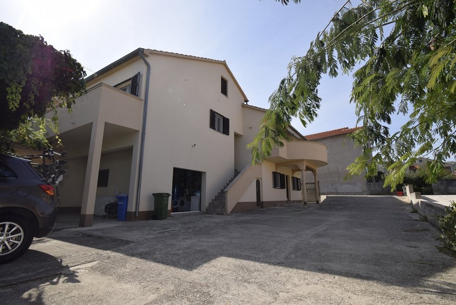 Lato della casa con tettoia per auto e piazzale lastricato