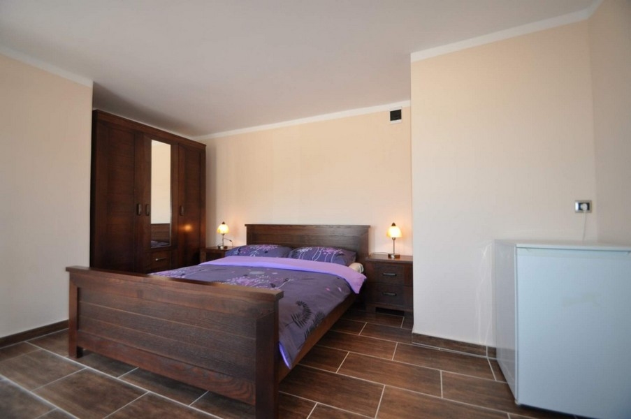 Camera da letto con letto in legno, armadio e frigorifero