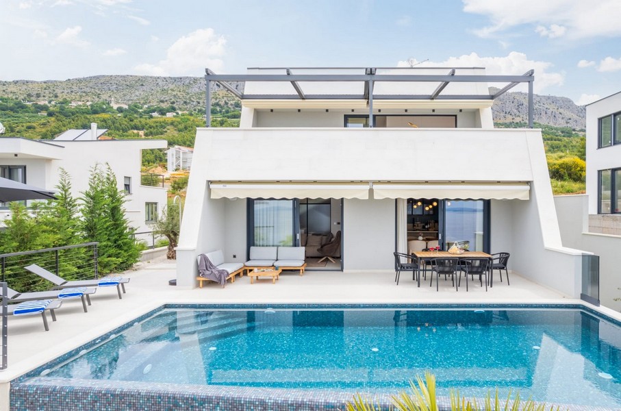 Villa bianca con piscina e tenda da sole sopra la terrazza