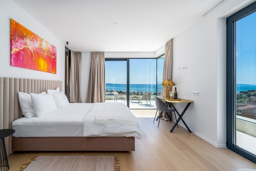 Camera da letto con grandi vetrate e vista mare