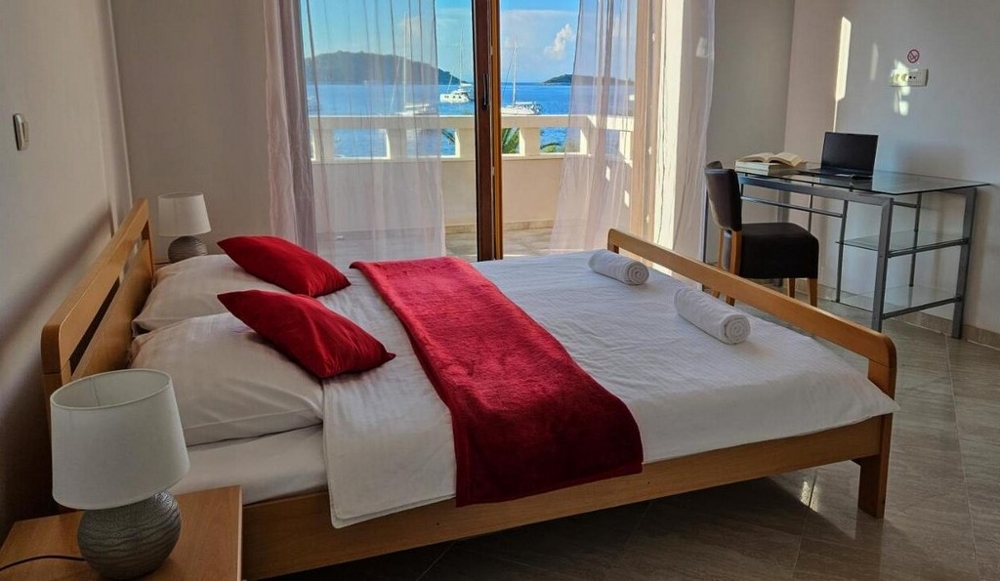 Bagno moderno con vasca, rivestimento di piastrelle chiare e arte alla parete.