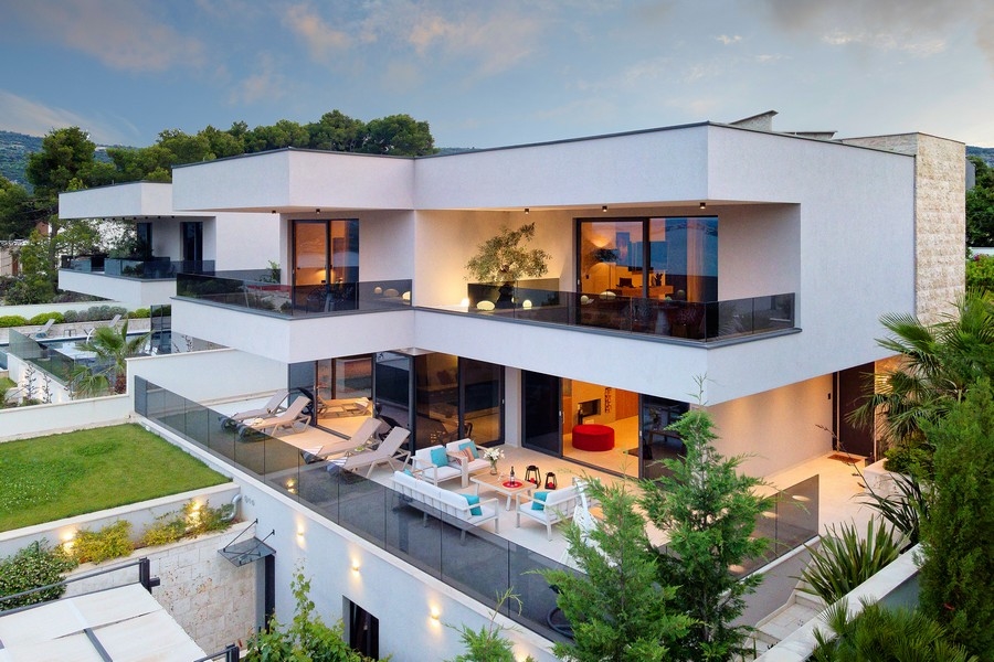 Villa illuminata con terrazze e mobili lounge di sera