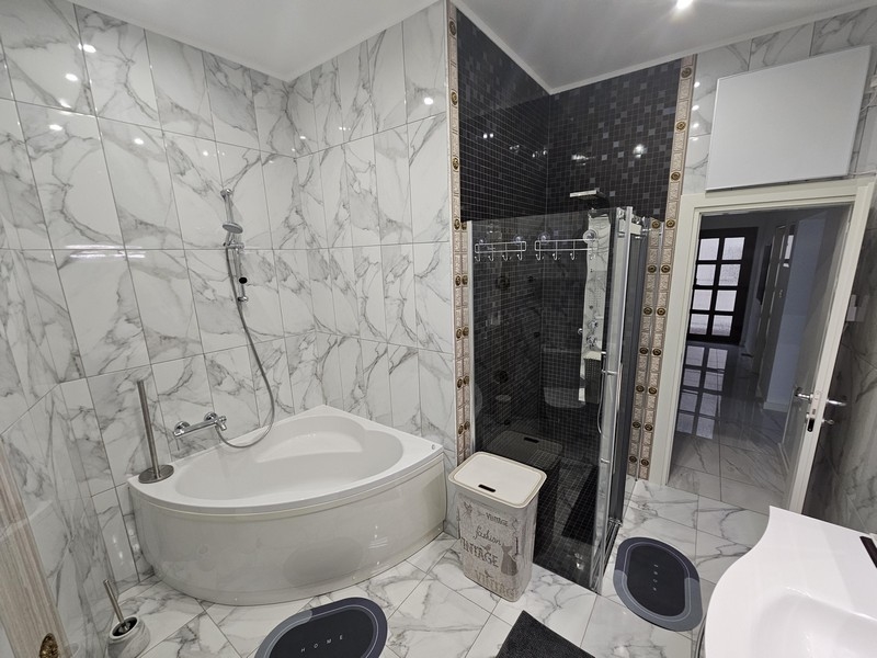 Elegante bagno effetto marmo con combinazione di vasca e doccia in un immobile croato