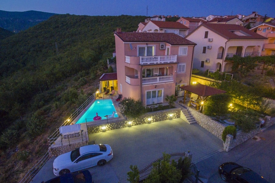 Vista serale di una casa plurifamiliare sul mare in Croazia con piscina illuminata - immobili Croazia