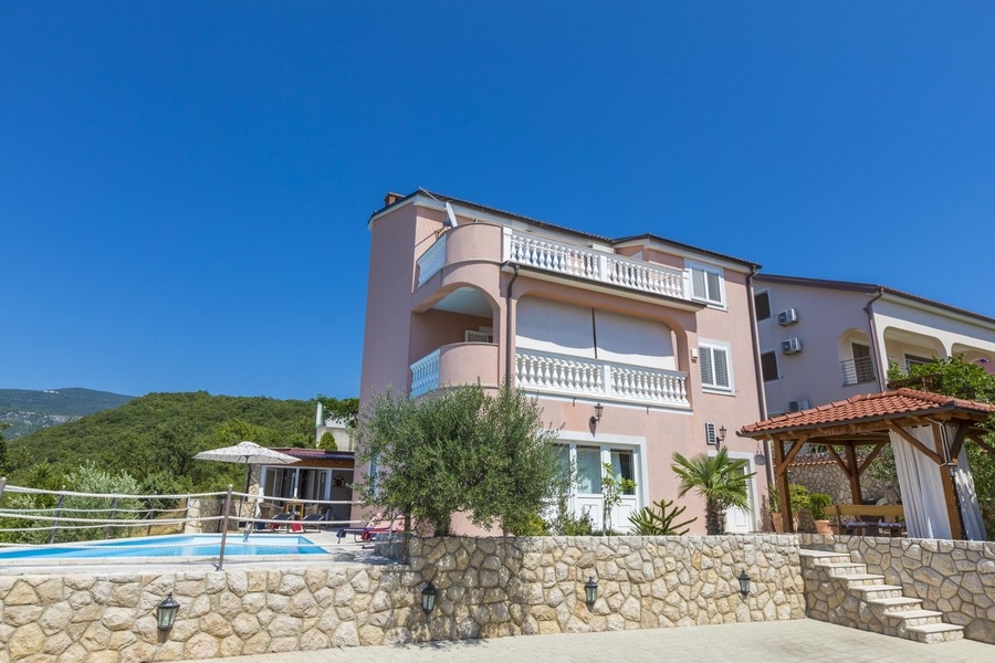 Vista diurna di una casa plurifamiliare rosa in Croazia con piscina