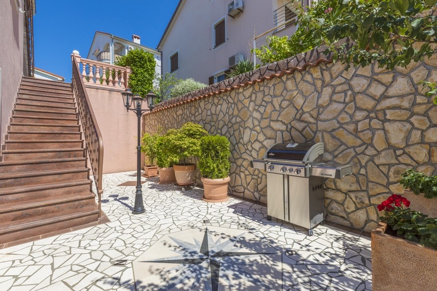 Area barbecue lastricata all'esterno della casa plurifamiliare in Croazia