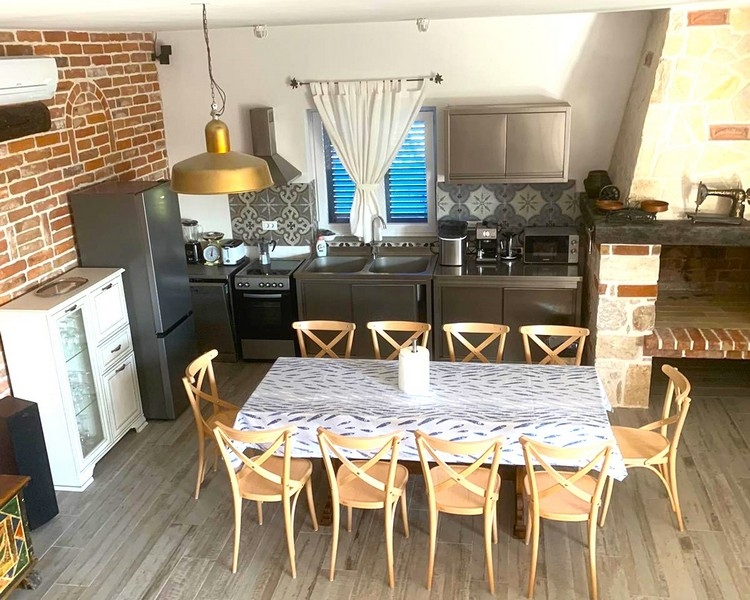 Cucina arredata in modo moderno con zona pranzo in una casa in pietra in vendita in Croazia.