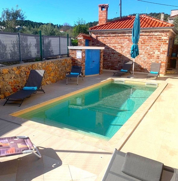 Area piscina di una casa in pietra in Croazia, ideale per giornate rilassanti all'aperto