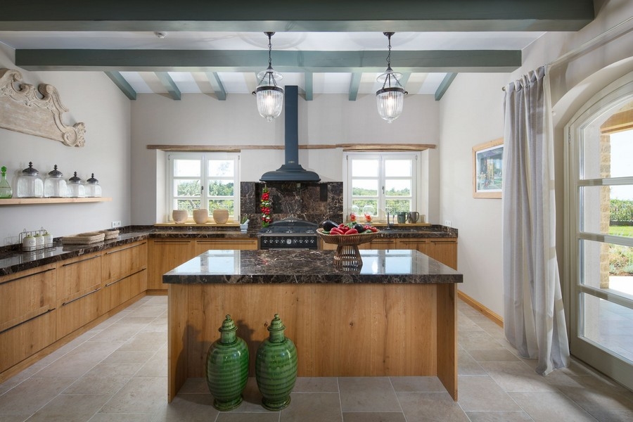 Cucina in stile rustico con travi in legno e isola cottura nella villa in Istria
