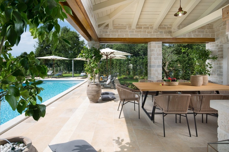 Terrazza coperta di una villa croata con tavolo da pranzo e vista sulla piscina.