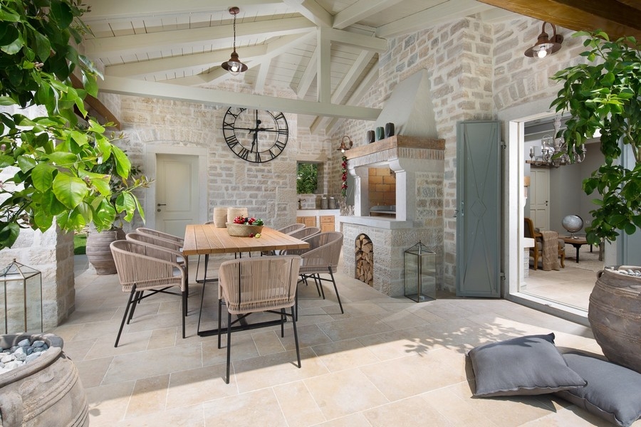 Accogliente terrazza con cucina esterna e muri in pietra in una villa in Croazia.