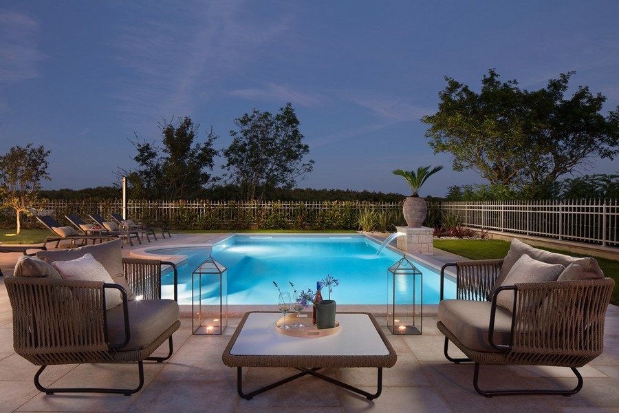Piscina con sdraio e illuminazione serale nella villa a Kanfanar