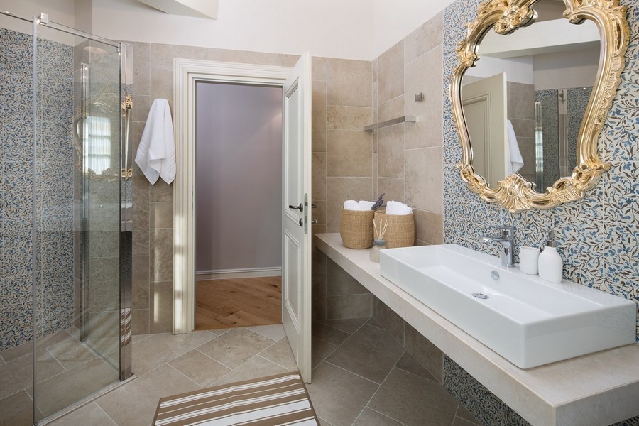 Bagno moderno con box doccia in vetro e specchio in una villa
