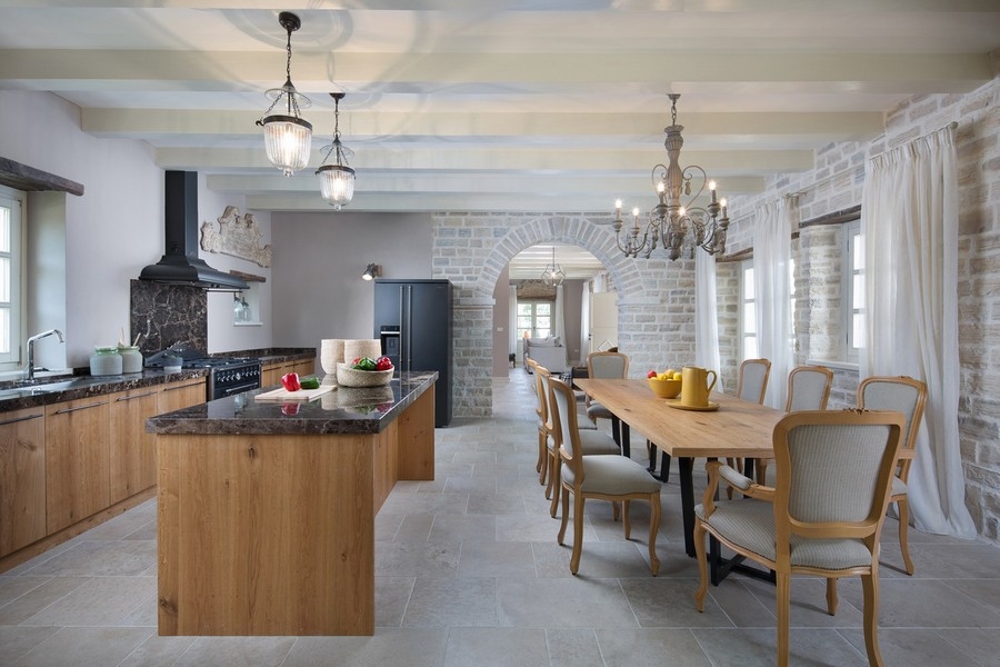 Cucina moderna con isola in legno e tavolo da pranzo in una villa a Kanfanar