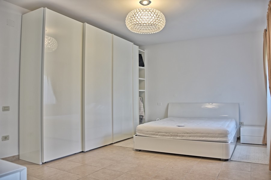 Camera da letto minimalista in una casa in Istria sul mare in vendita.
