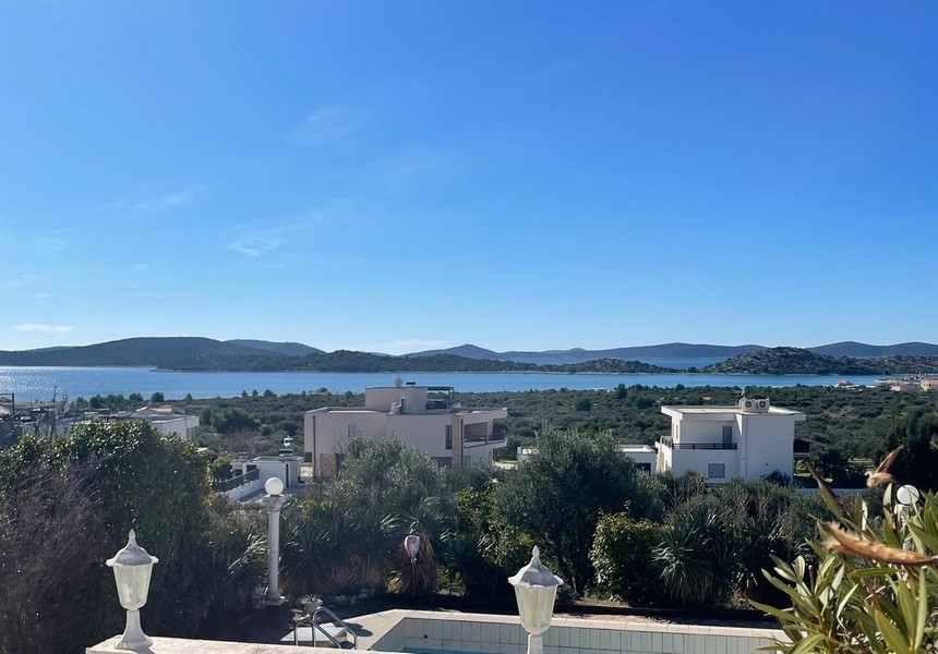 Vista grandangolare della piscina e della villa con vista mare in lontananza in Croazia