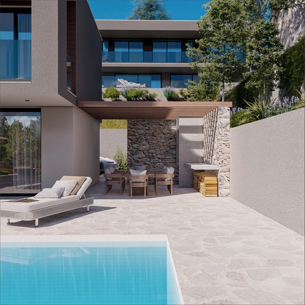 Area piscina di una villa moderna con zona pranzo all'aperto e muro in pietra in Croazia.
