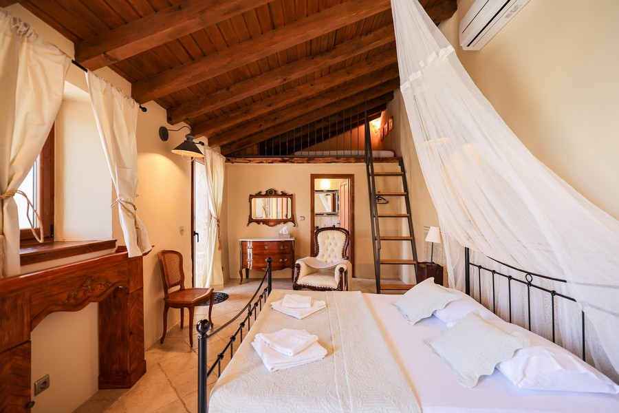 Arieggiata camera da letto con letto a baldacchino in una casa in pietra croata