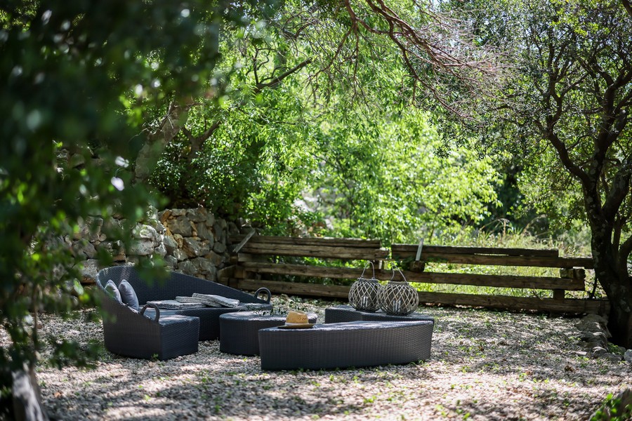 Ombreggiata area lounge esterna nel giardino di una casa in pietra croata
