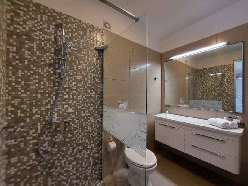 Bagno moderno con doccia walk-in e piastrelle a mosaico a Rovinj