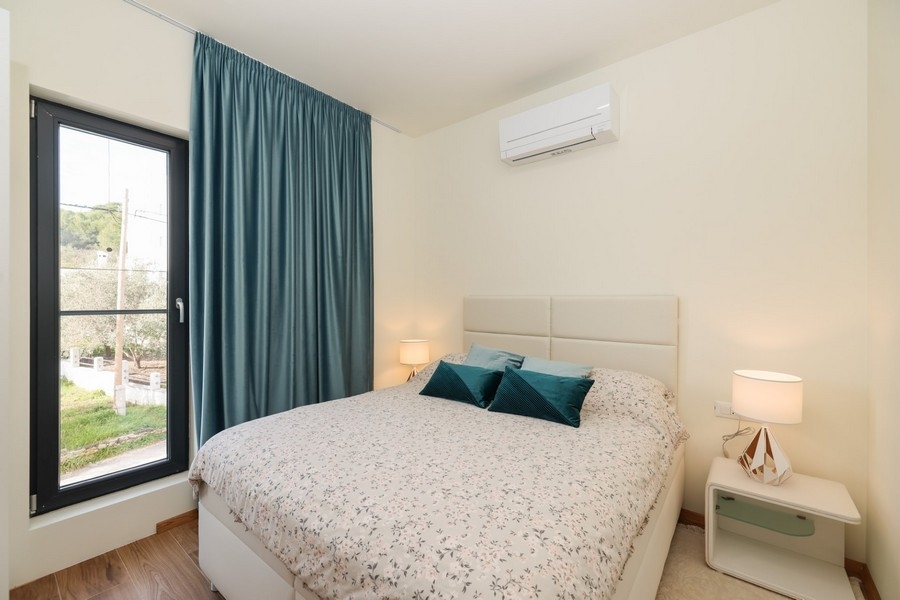 Camera da letto con letto matrimoniale, colori chiari e vista dalla finestra